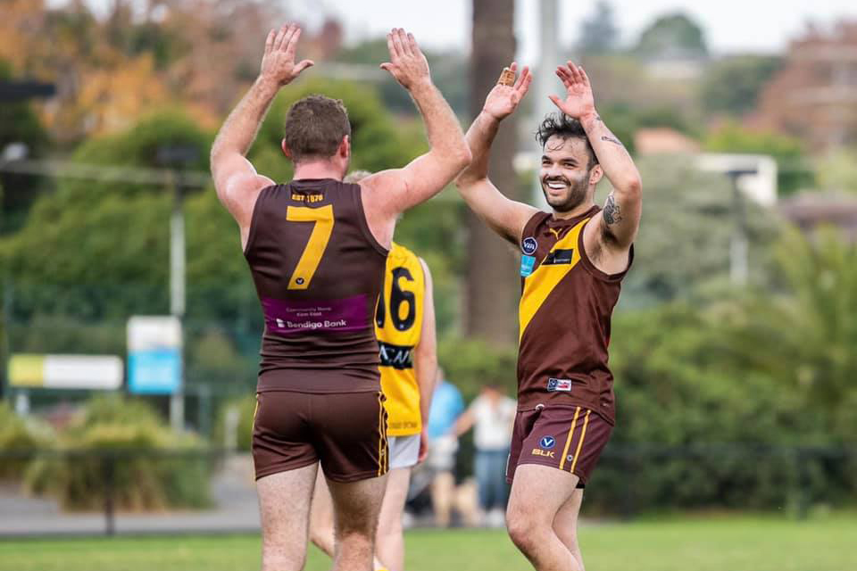 Two Kew men's players high fiving on the field